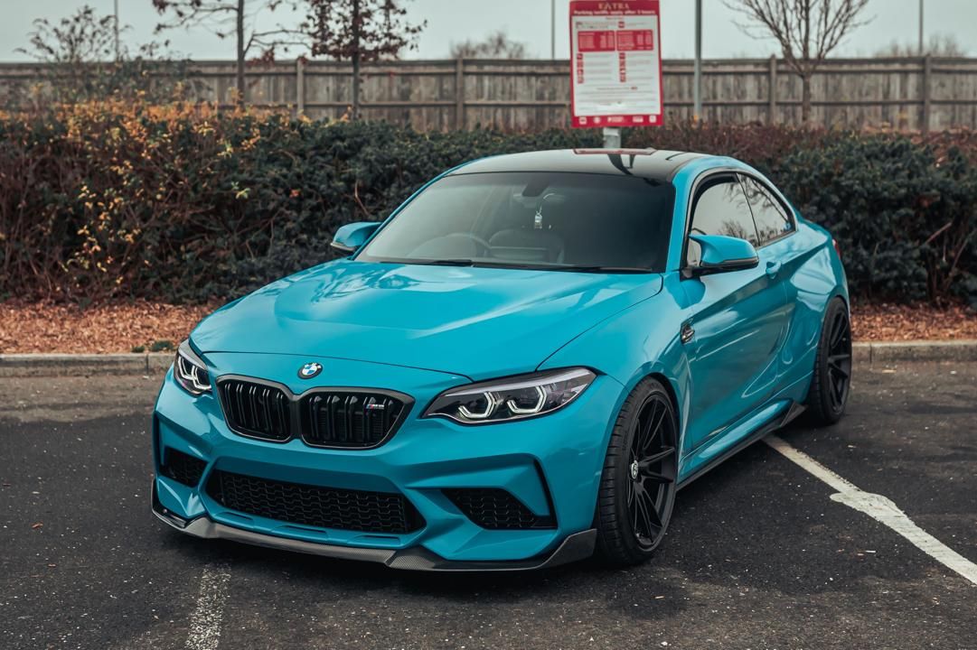 Our blue BMW M2 with carbon roof and black wheels in a car park